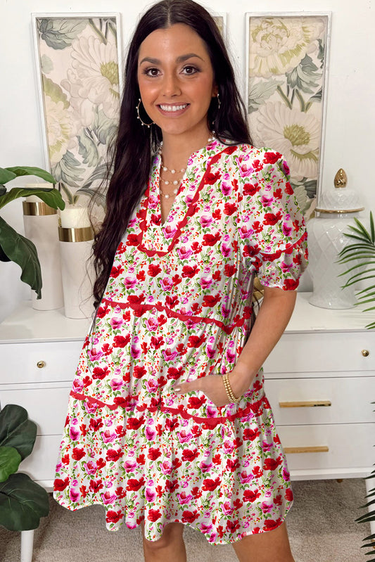 Woman wearing a floral dress in a home setting with decorative elements.